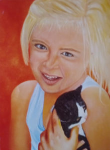 A young blonde haired girl holding a black and white kitten